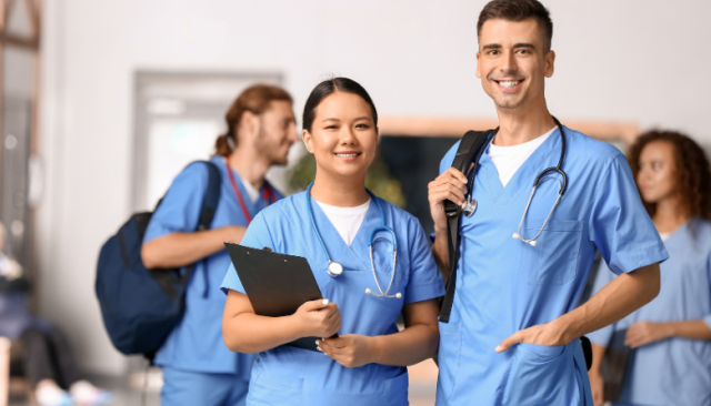 students wearing scrubs and backpacks smile together