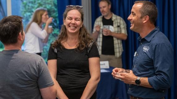 Dan Collins, the director of Lane SBDC laughs with a business client at a showcase