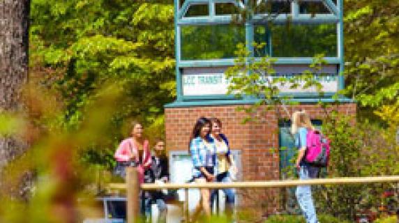 students by clock tower at main campus bus station