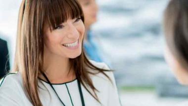 smiling woman shaking hands with another person