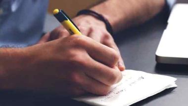 close up of man writing in a notebook