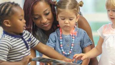 teacher reading a book to kids