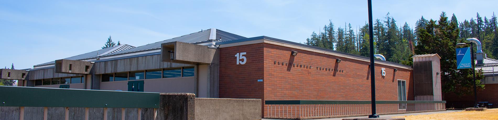 exterior of Building 15 on a sunny day with forest in background