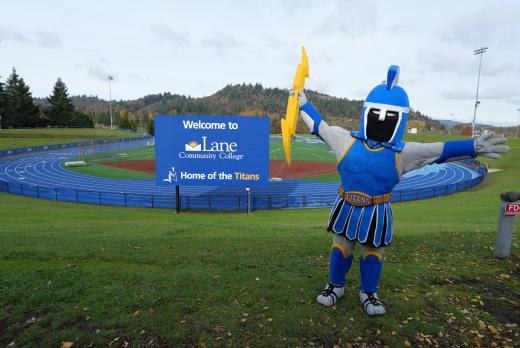 LCC Mascot Ty the Titan at track with welcome sign