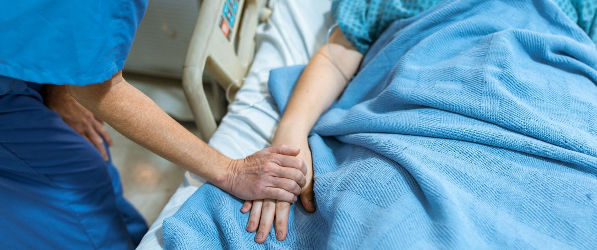 a nurse holding a patient's hand