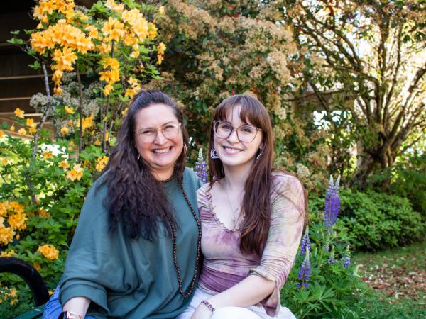 Aya & Emma Lyddon smiling together with flowers in background