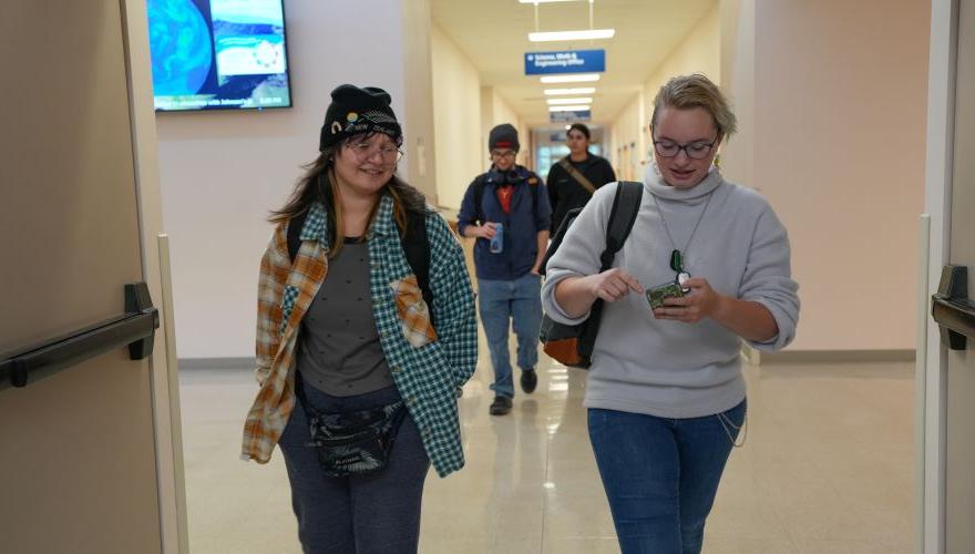Students talking to each other and walking to class in the science building