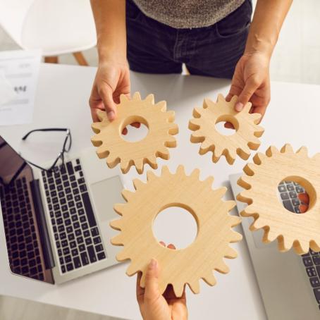 people fitting gears together at a desk