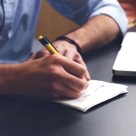 close up of man writing in a notebook