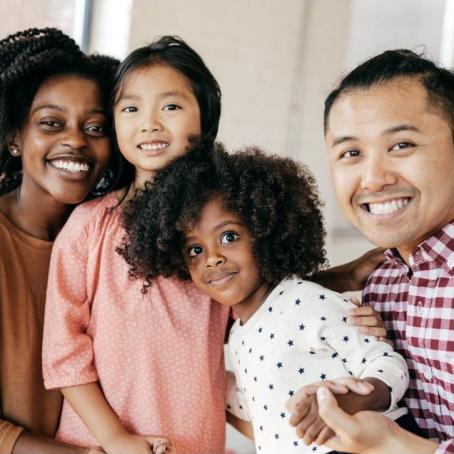 happy family of four smiling at the camera