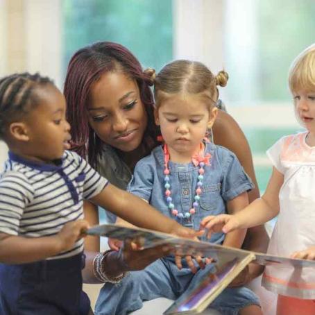 teacher reading a book to kids